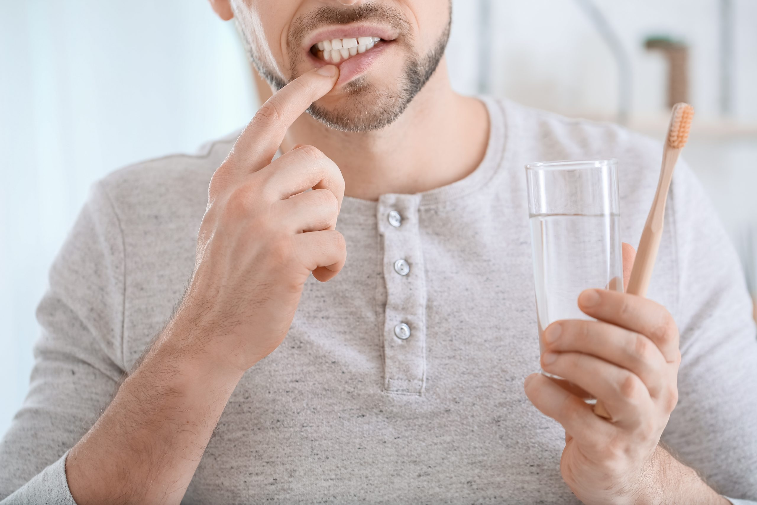 Man suffering from pain while brushing teeth in morning